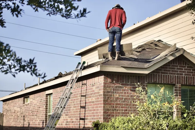 Professional roofer working on a residential roof in East Northport